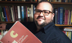O pesquisador Thiago Dias com obra da Coleção Linhares.